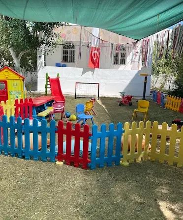 Renkli çitli, oyun evli ve kaydıraklı bahçe oyun alanı