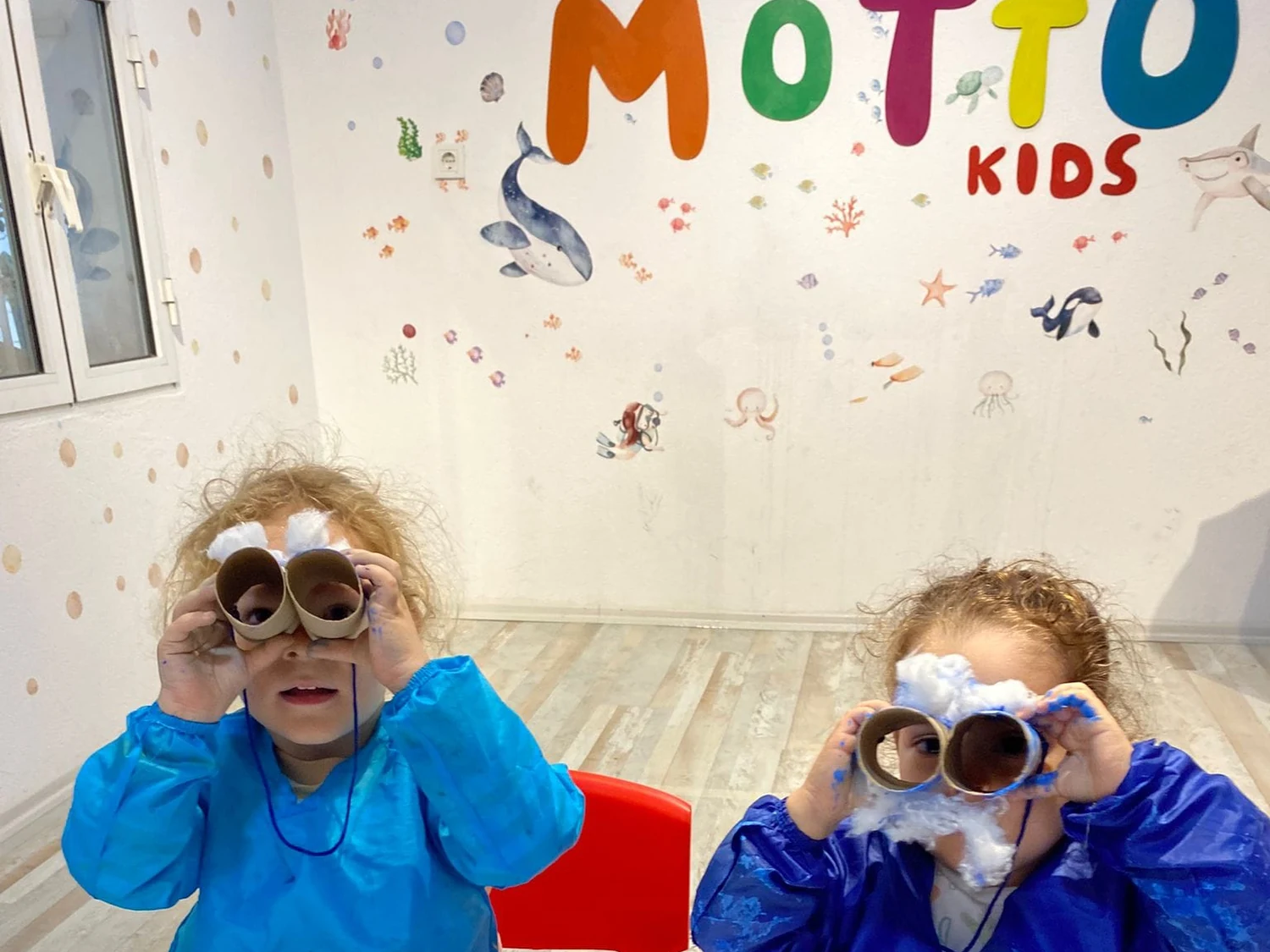 Motto Kids sanat atölyesinde el yapımı dürbünlerle oynayan mutlu çocuklar